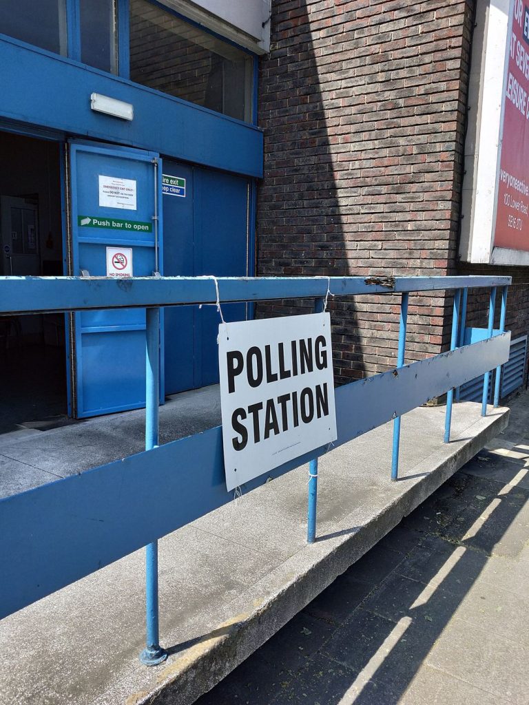 The entrance of a polling station with a sign outside